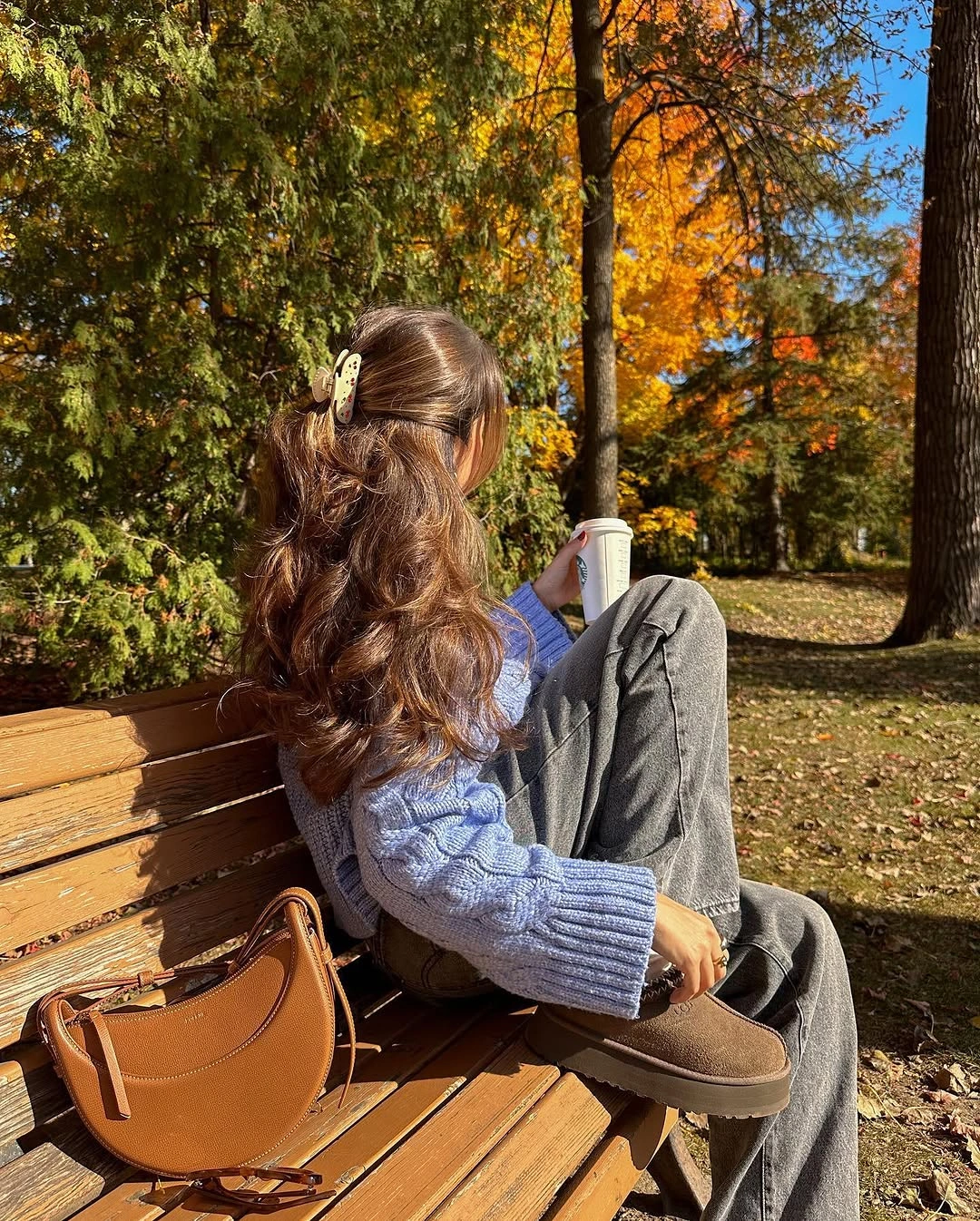 Cream cable-textured sweater with pale pants and brown flats