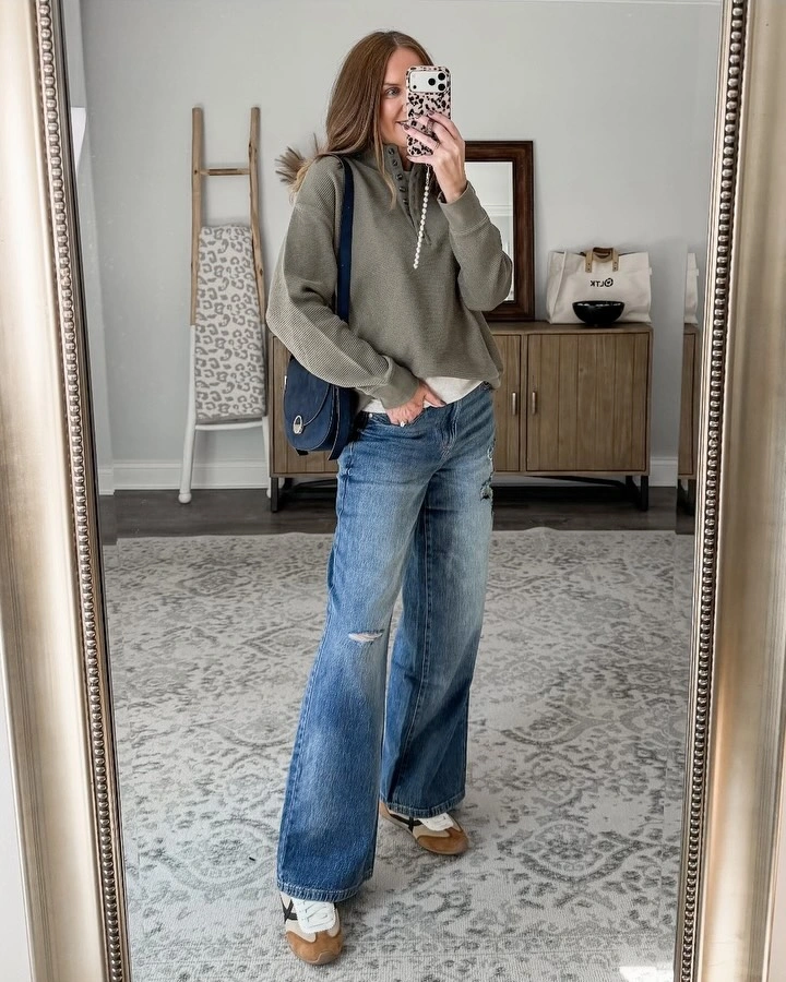 Gray green hoodie with wide ripped jeans and blue bag