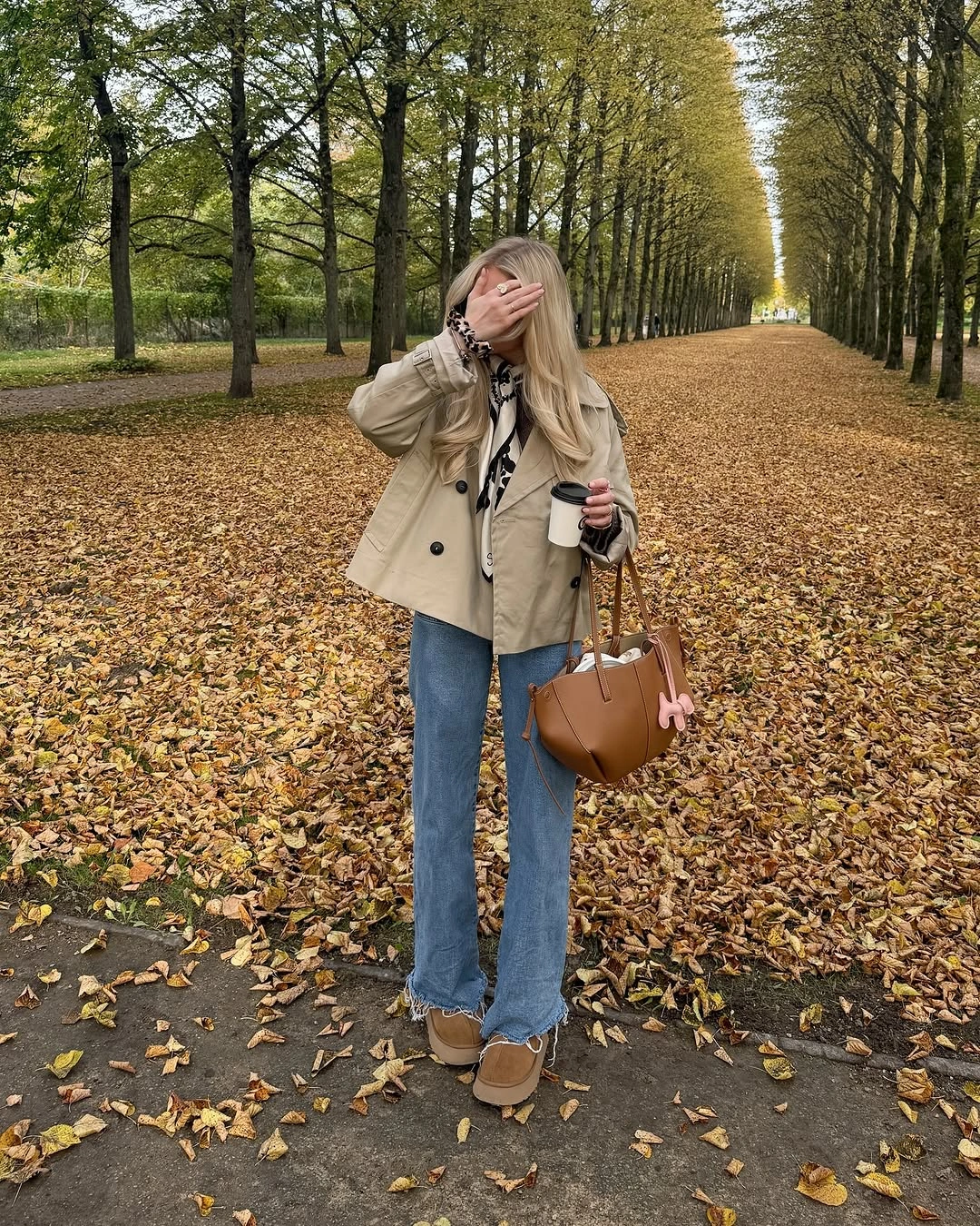 Beige jacket with blue jeans, tan boots and handbag