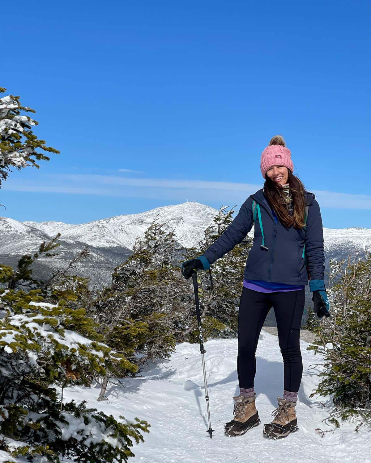 Dark Blue Jacket and Pink Beanie with Hiking Poles — Winter Hiking Outfits