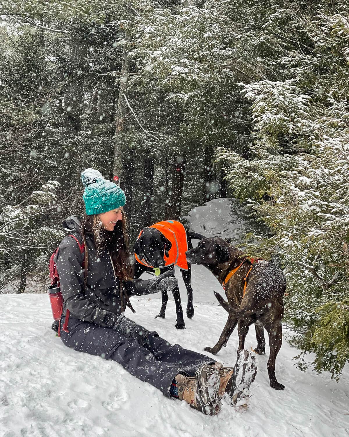 Black Puffer with Teal Beanie and Red Backpack — Winter Hiking Outfits