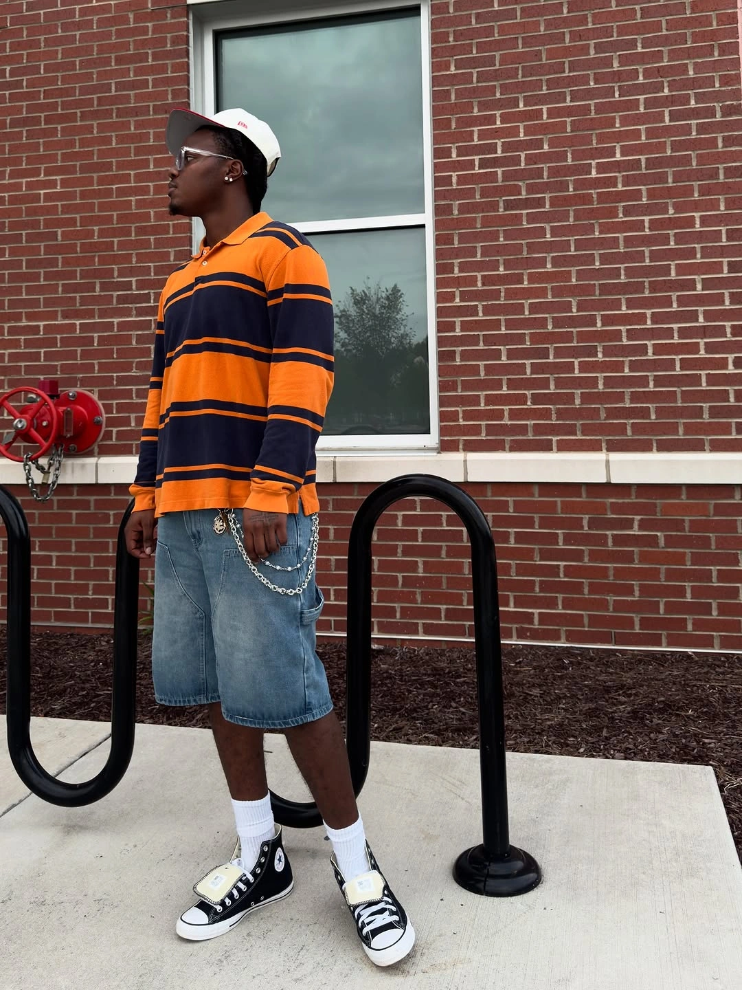 Orange black striped polo blue denim shorts cap and high top sneakers