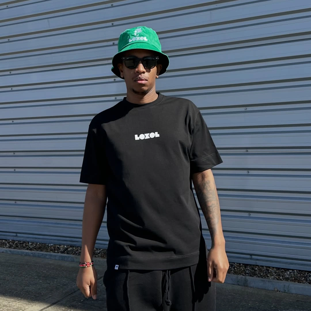 Black T shirt and shorts with green bucket hat sunglasses