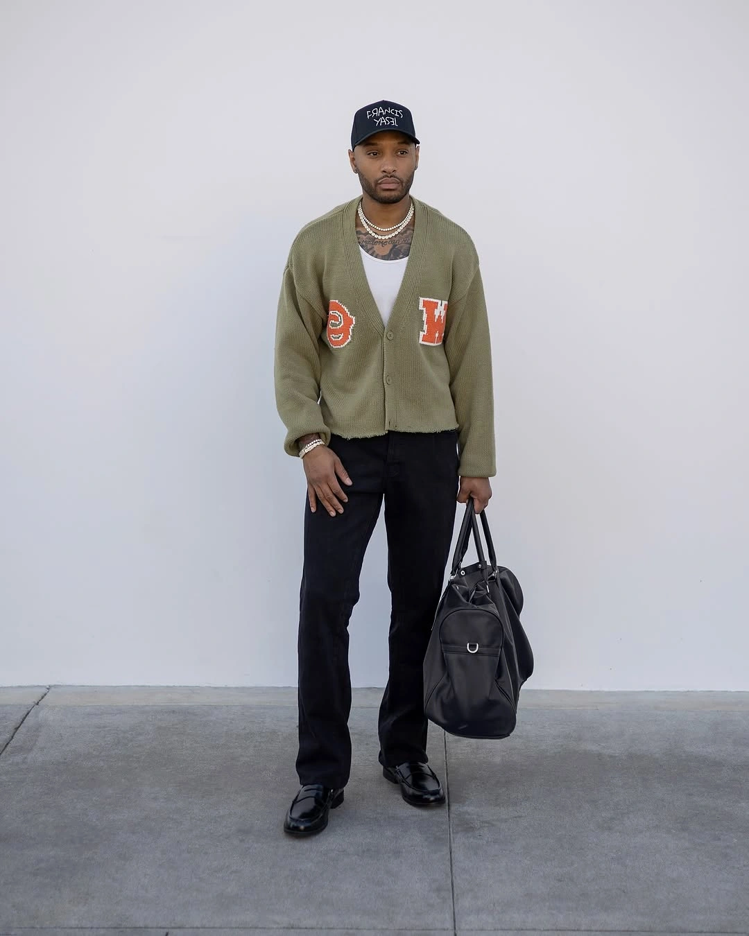 Olive patched cardigan black trousers cap necklace and black bag