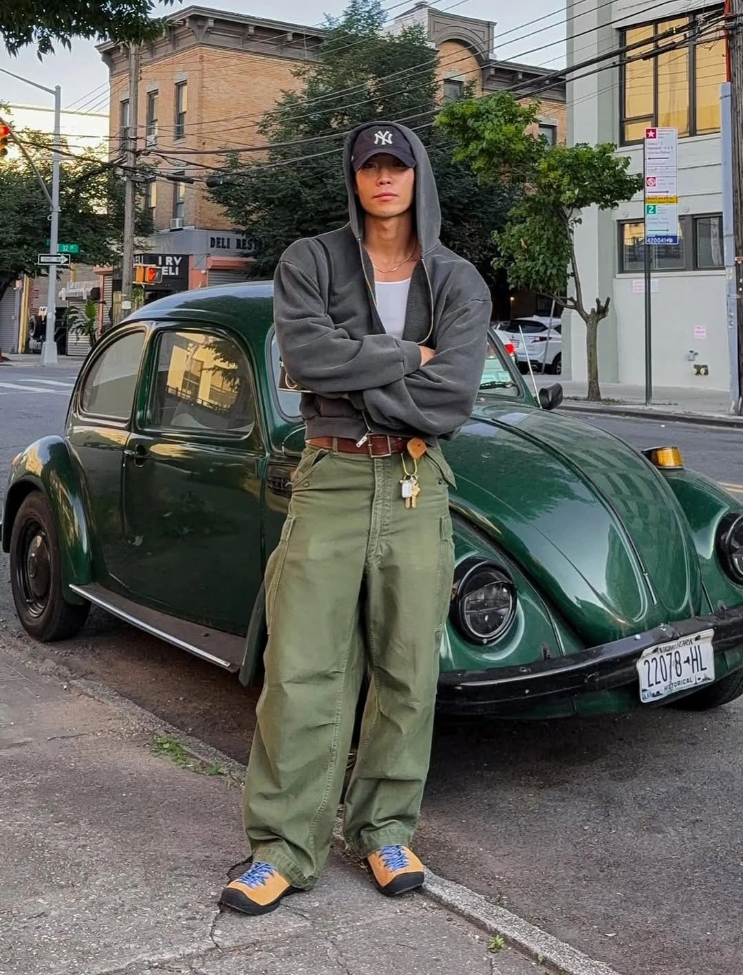 Charcoal hoodie with olive cargo pants cap and orange accent sneakers