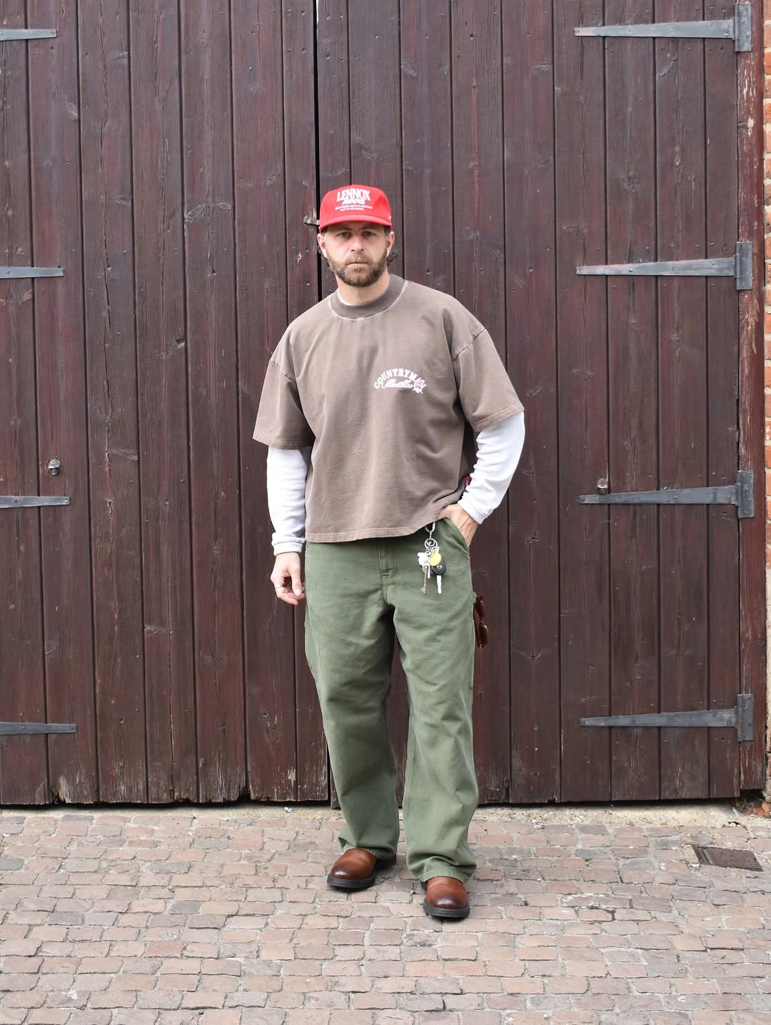 Brown graphic T shirt white long sleeves olive cargo pants red cap