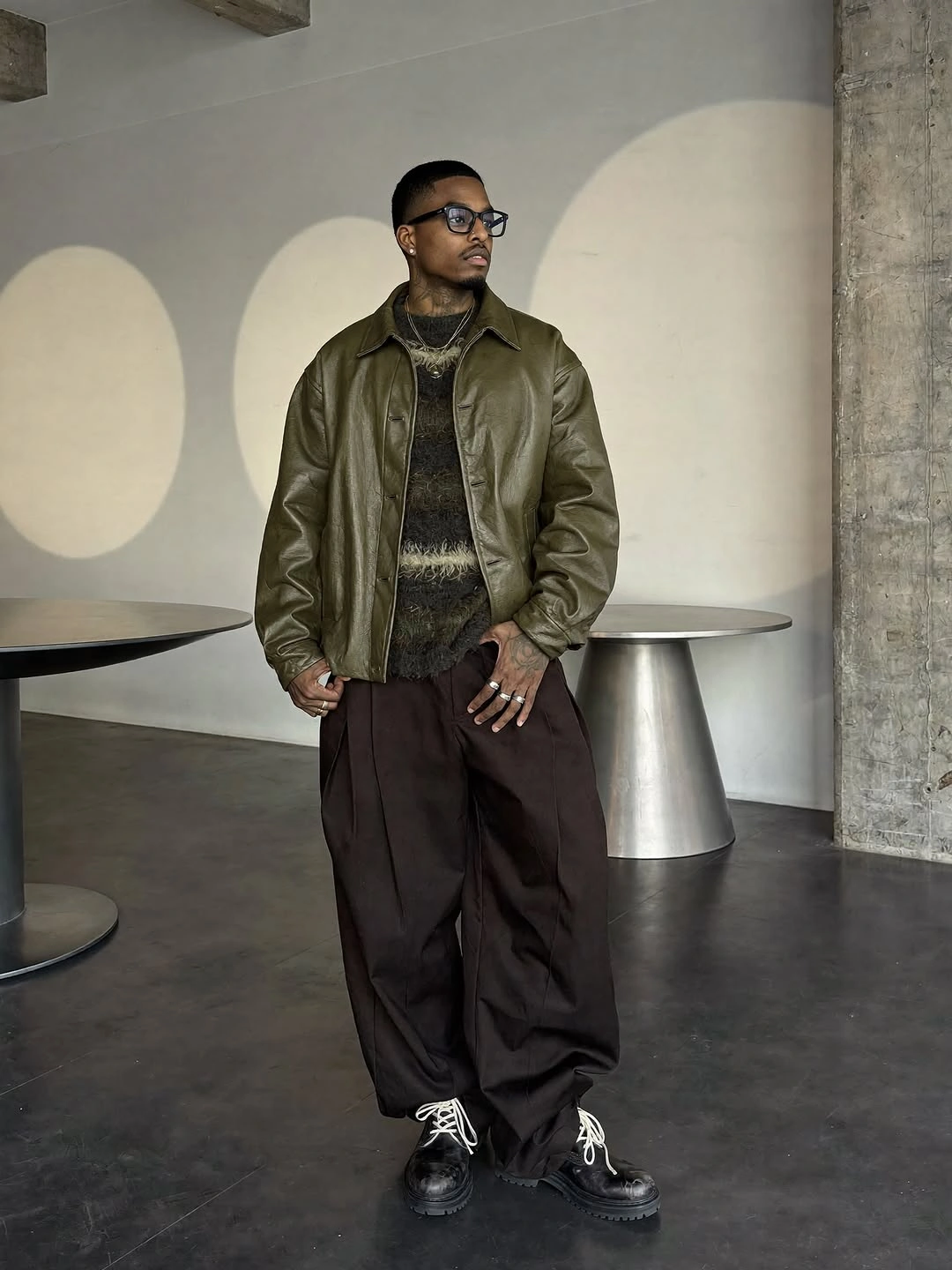 Olive bomber jacket dark knit brown wide trousers and black shoes