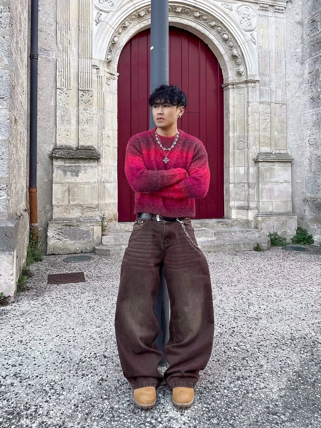 Red patterned sweater with very wide brown trousers and tan shoes