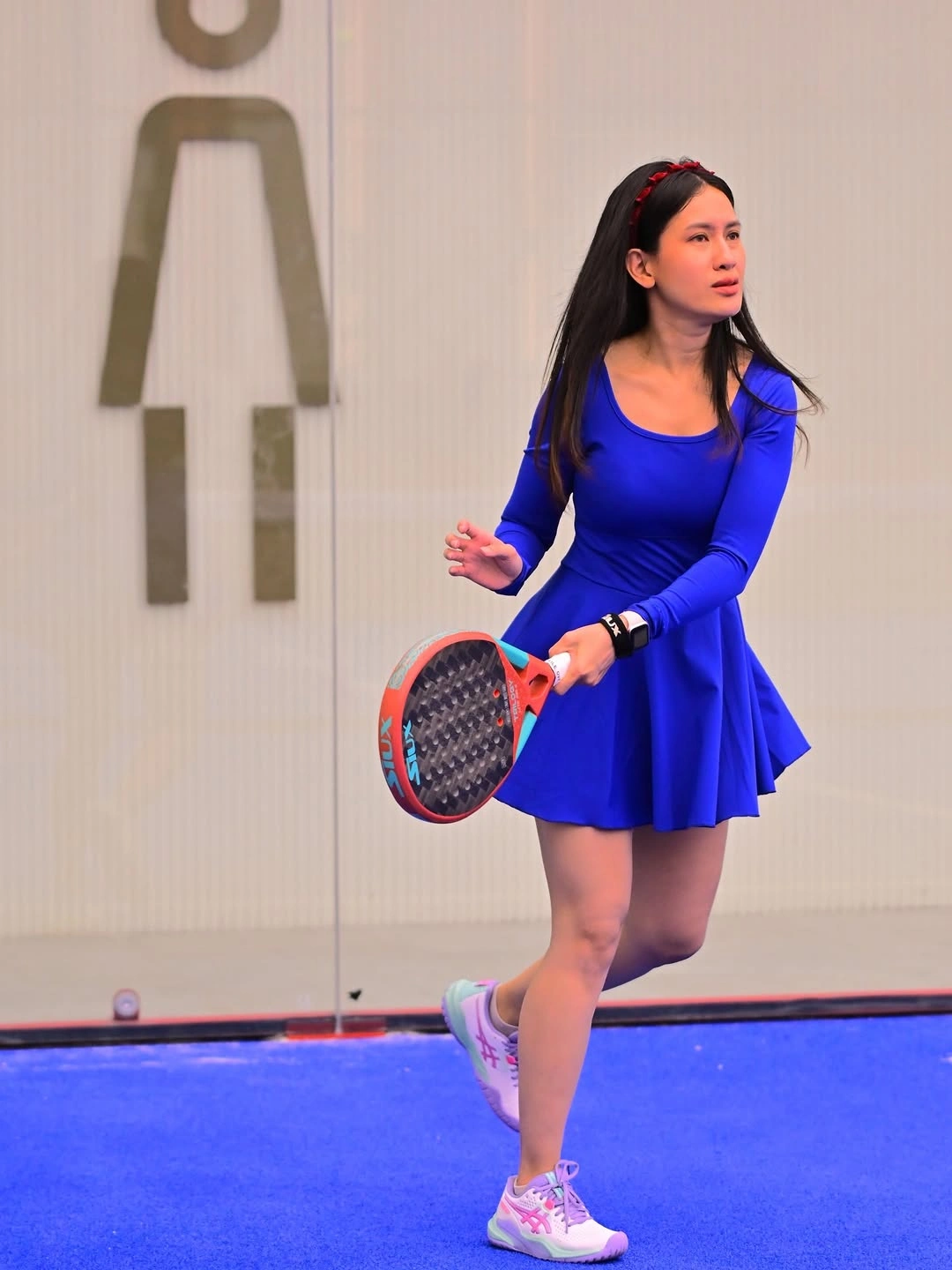 Bright blue sleeveless athletic dress pink shoes and padel racket