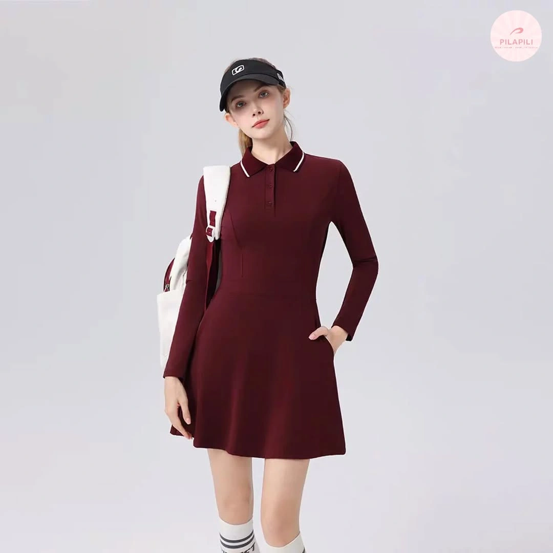 Burgundy long sleeve collared athletic dress with white visor and racket