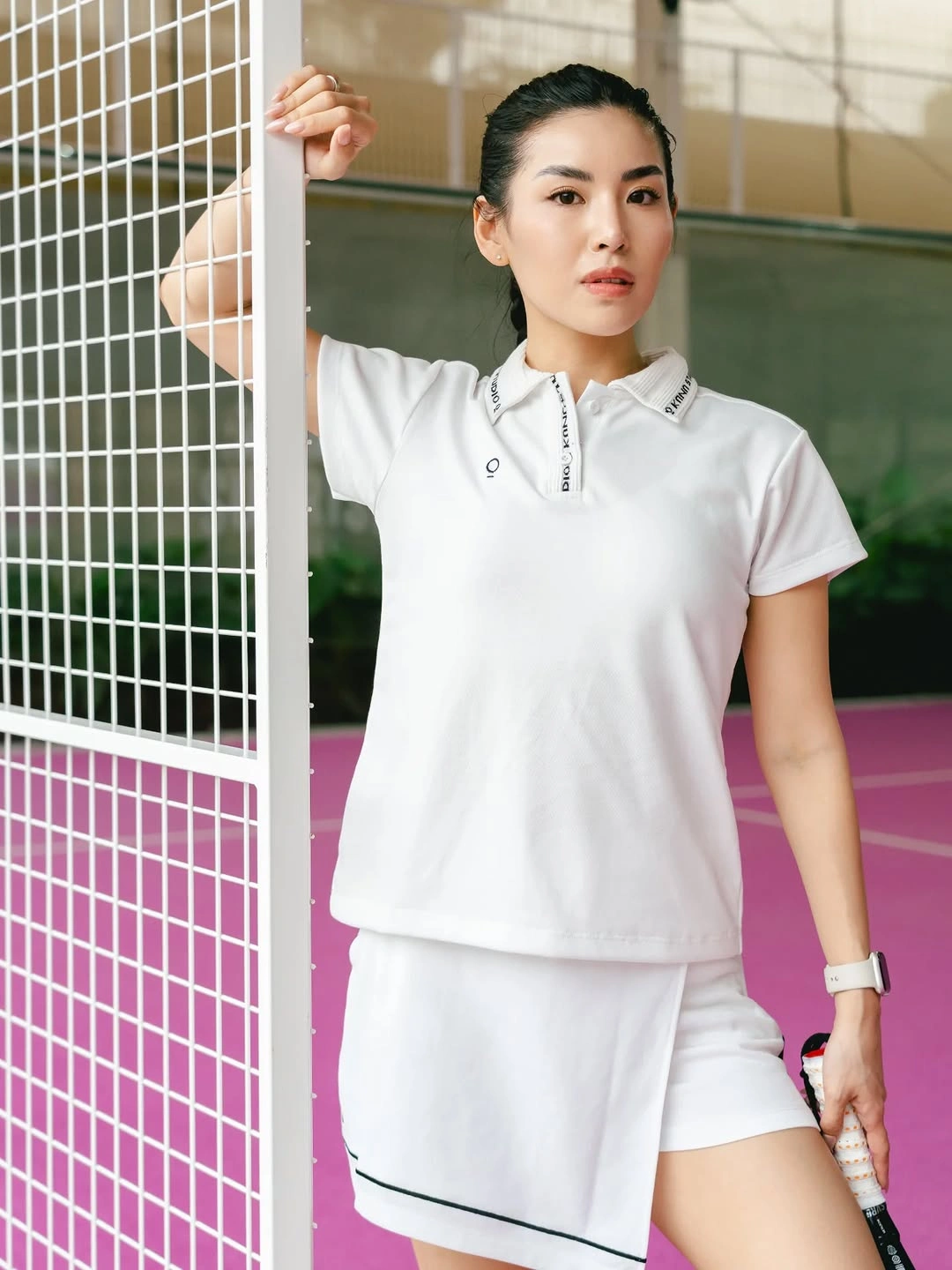 White short sleeve polo with white athletic lower half and padel racket