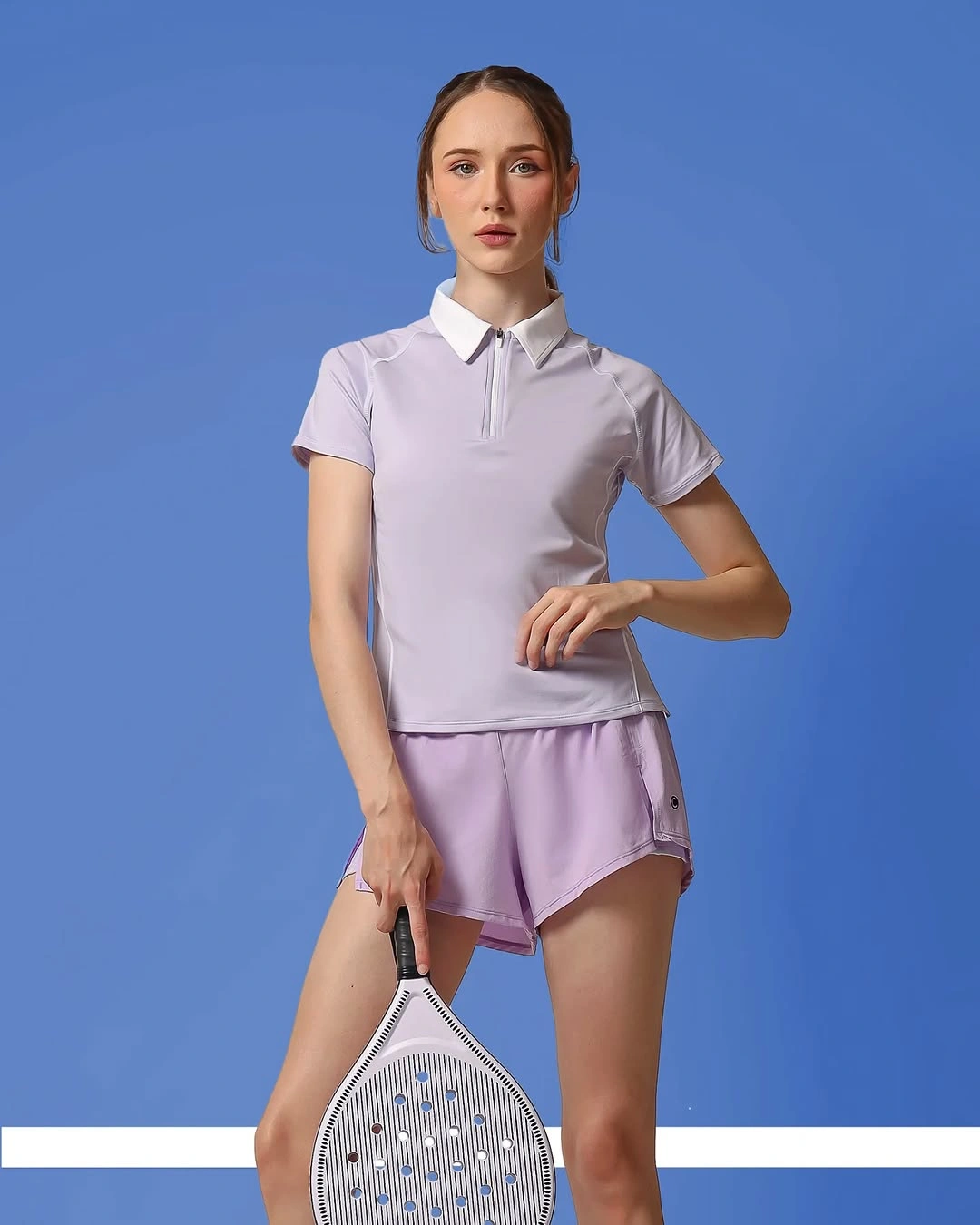 Lilac polo matching shorts white collar and pale padel racket
