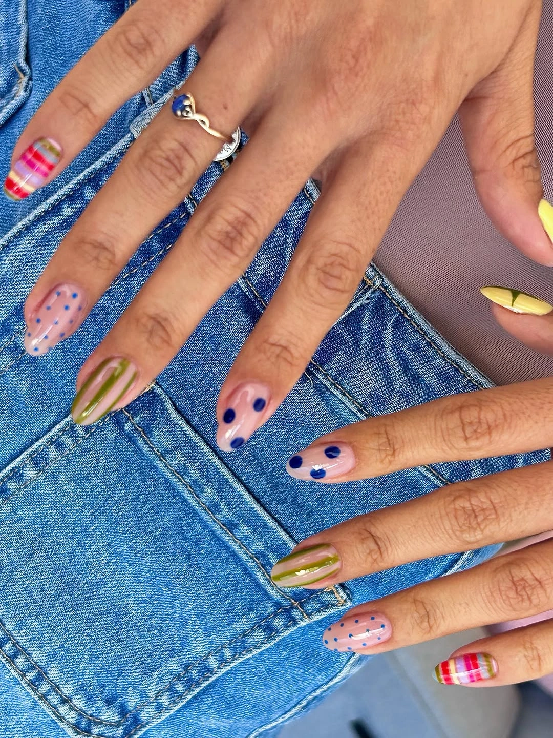 Short rounded nails with mixed colorful dots stripes and graphic details