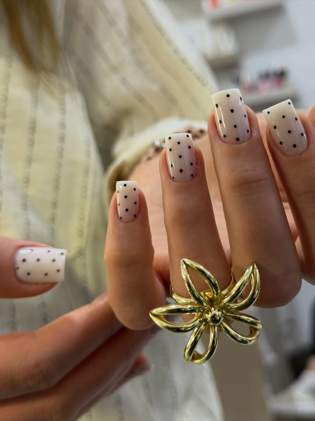 Short square nude nails with white French tips and tiny black dots