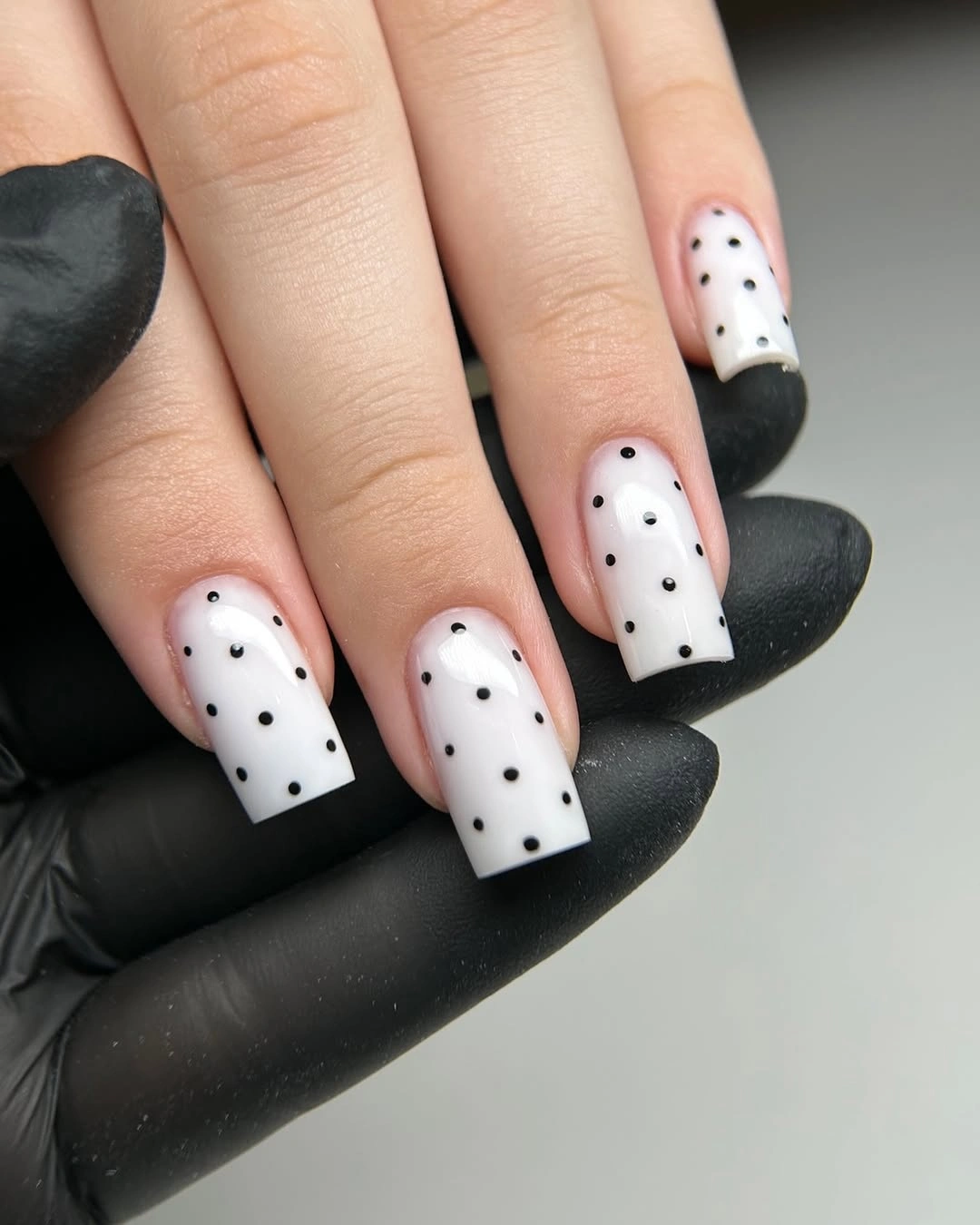 Medium square nude nails with white French tips and black dots