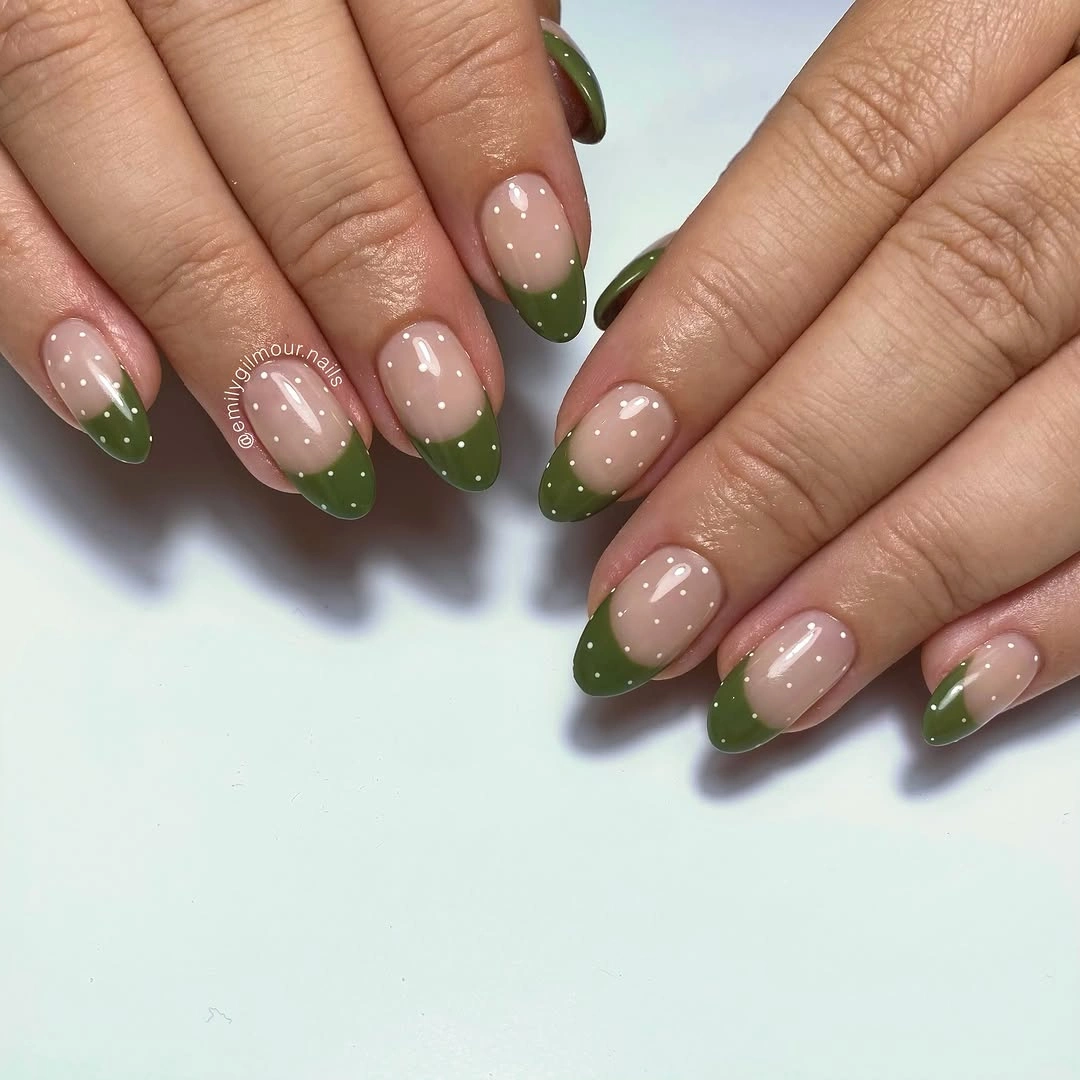 Nude almond nails with olive green French tips and black dots