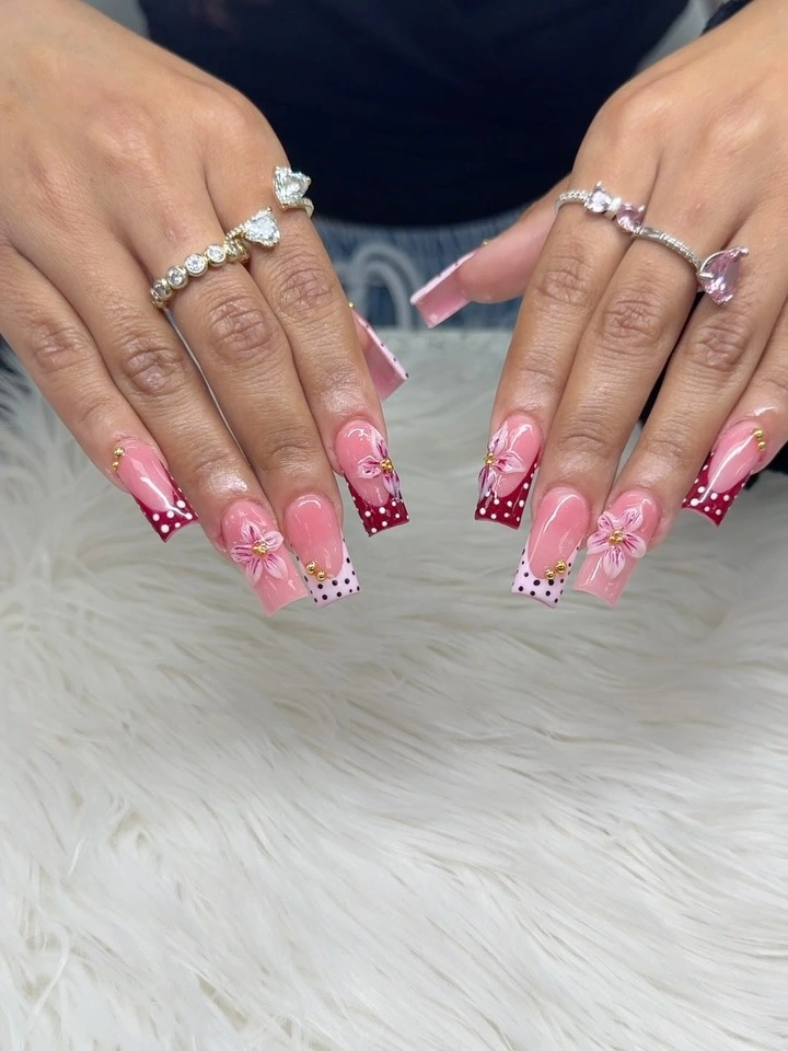 Long square pink French nails with dots and floral accents