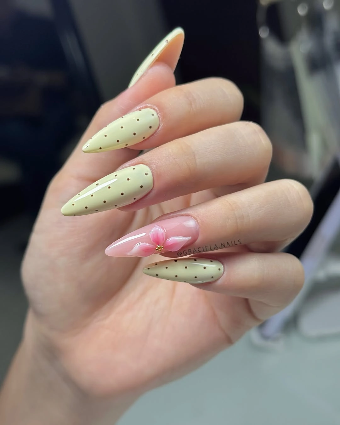Lime and pink almond nails with small black dots and flower detail