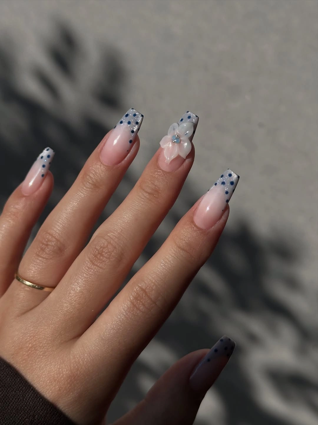 Nude almond nails with blue black dotted accents and small detail