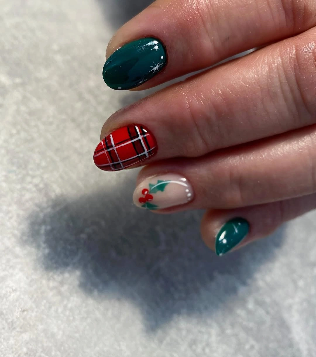 Deep teal short nails with red plaid and holly accents