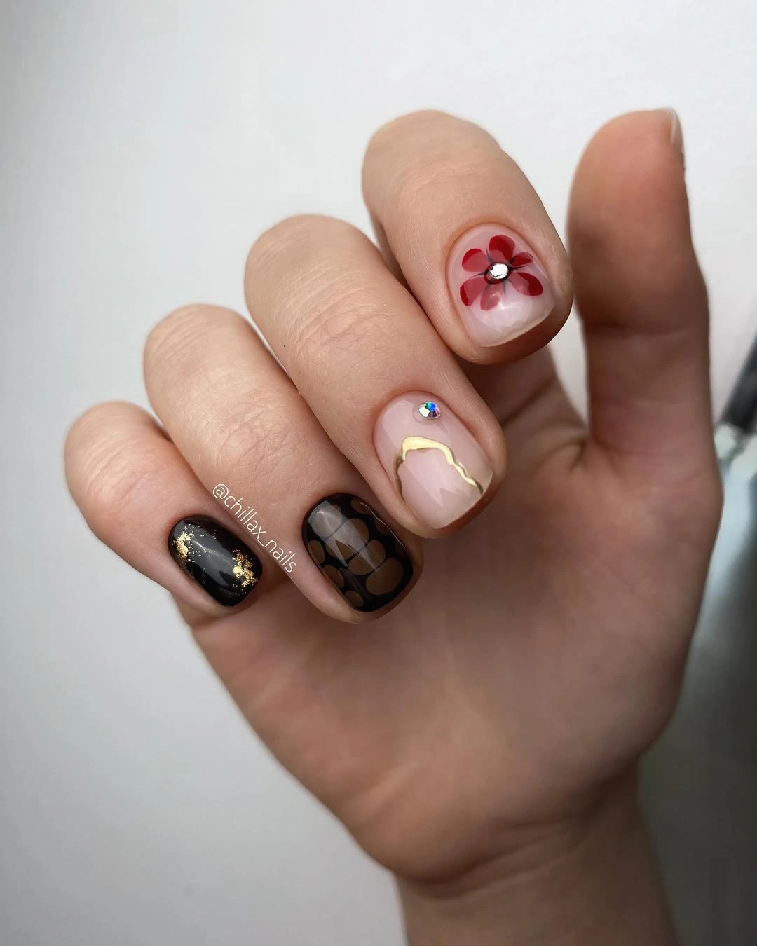 Very short mismatched nails with black nude red and gold details
