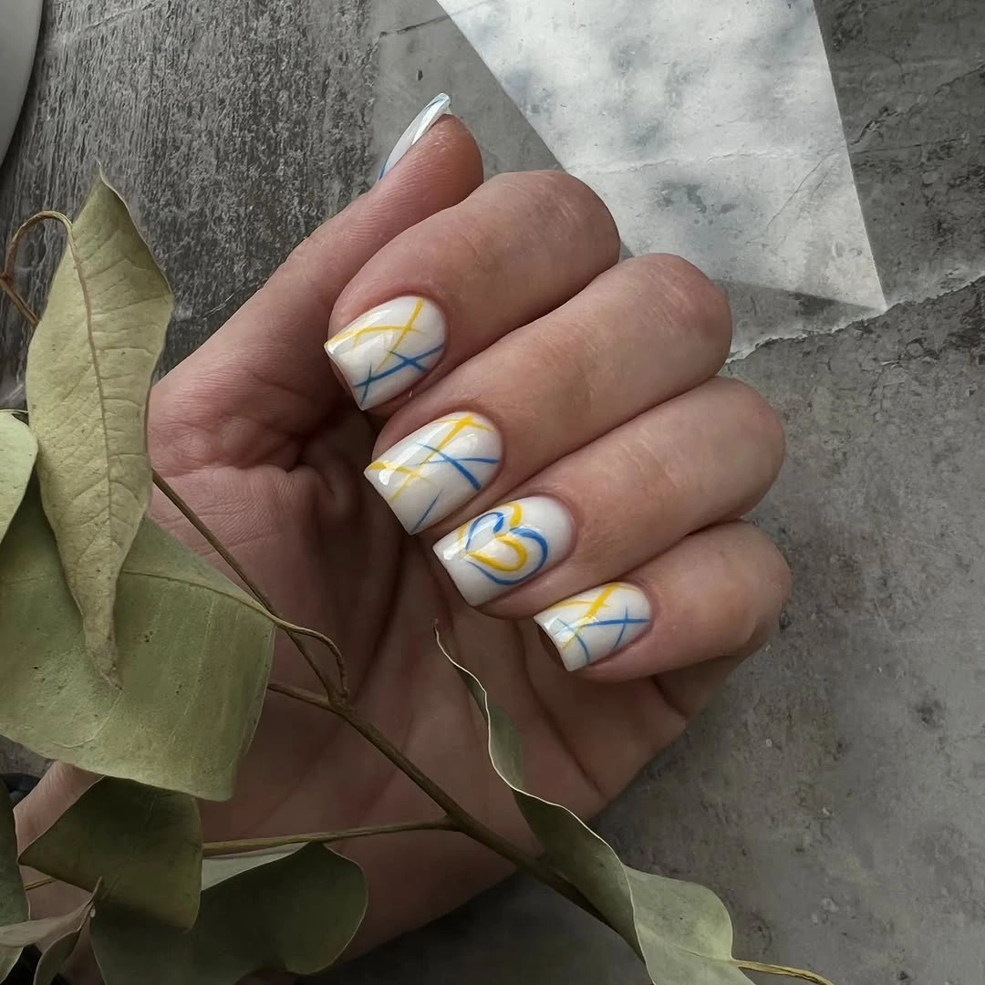 White short nails with thin blue and yellow diagonal lines