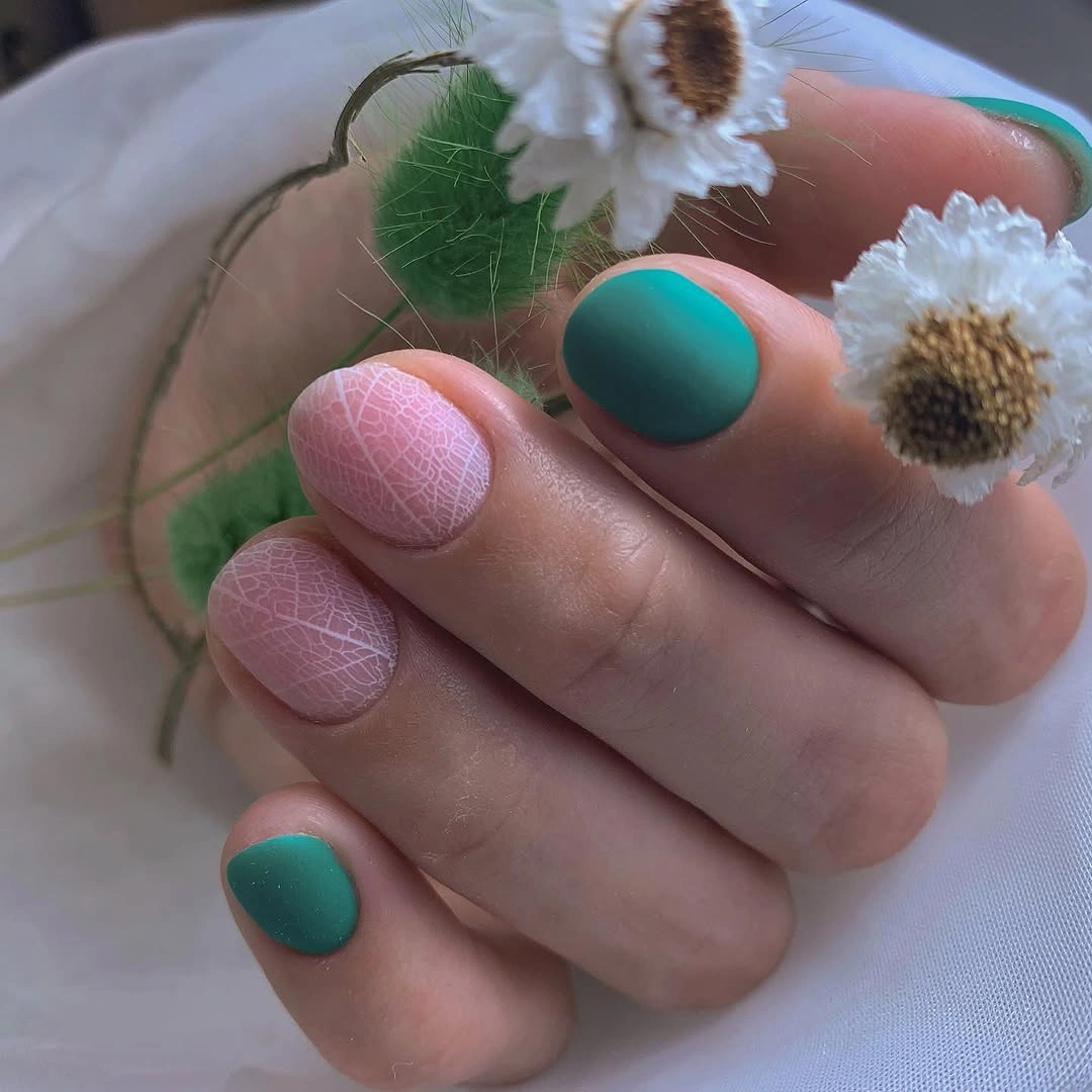 Teal solid nails with pink crackle-like patterned short nails