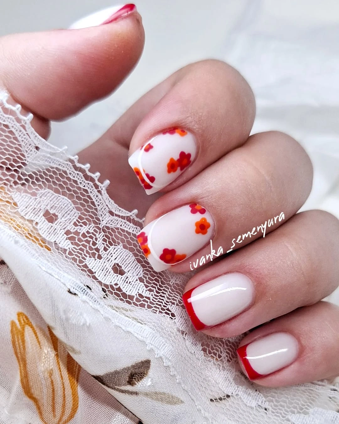 Milky white short nails with red tips and small flowers