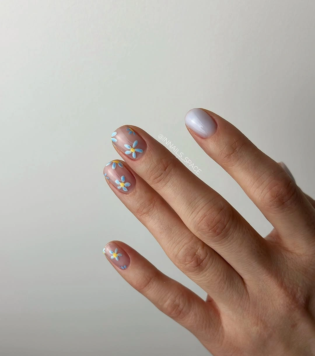 Sheer short nails with tiny blue yellow and white flowers