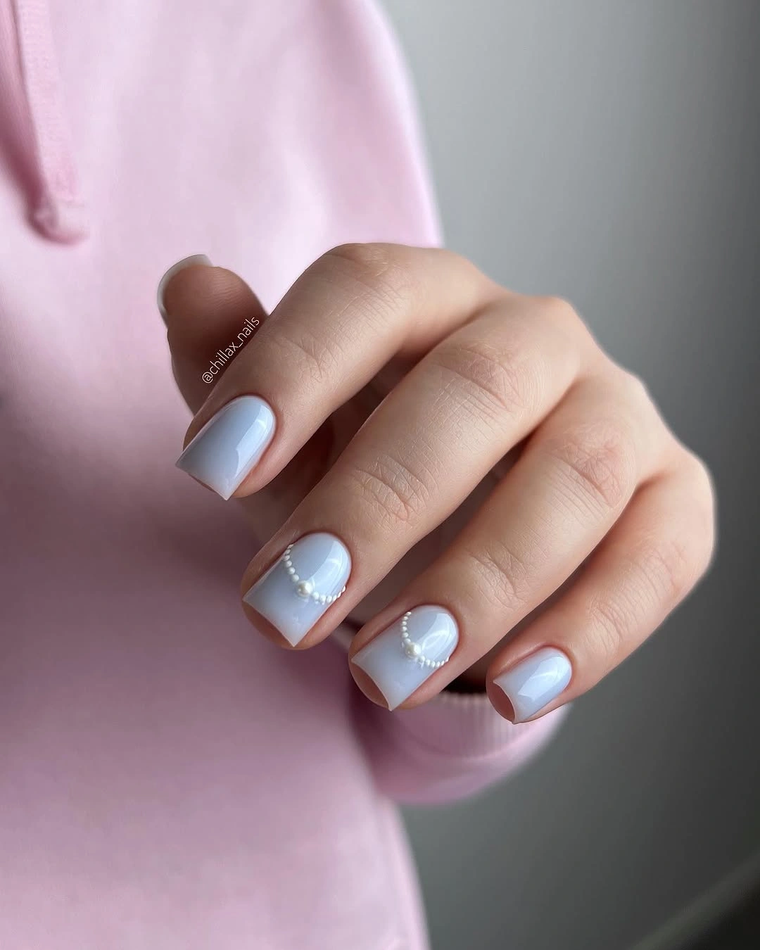 Soft blue short square nails with curved pearl accent lines