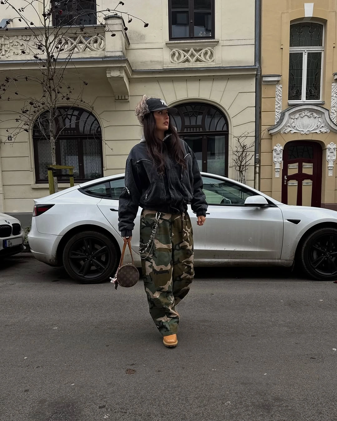 Oversized black jacket with camouflage cargo pants and tan boots