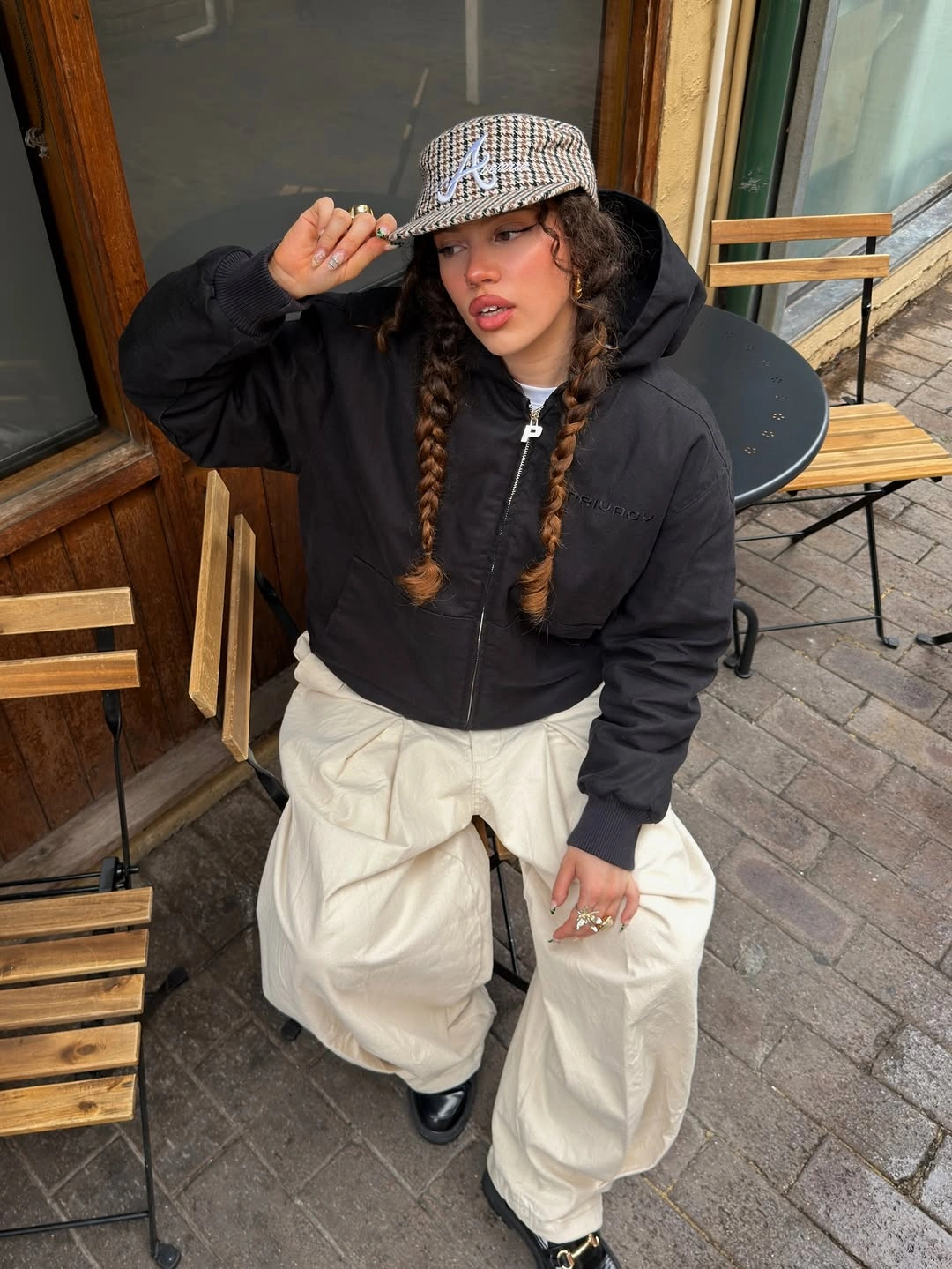 Black puffer with cream parachute pants and patterned cap