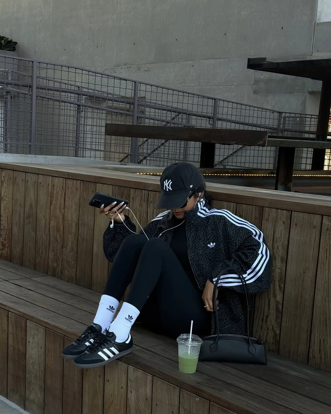 Black track jacket and leggings with white socks and sporty sneakers