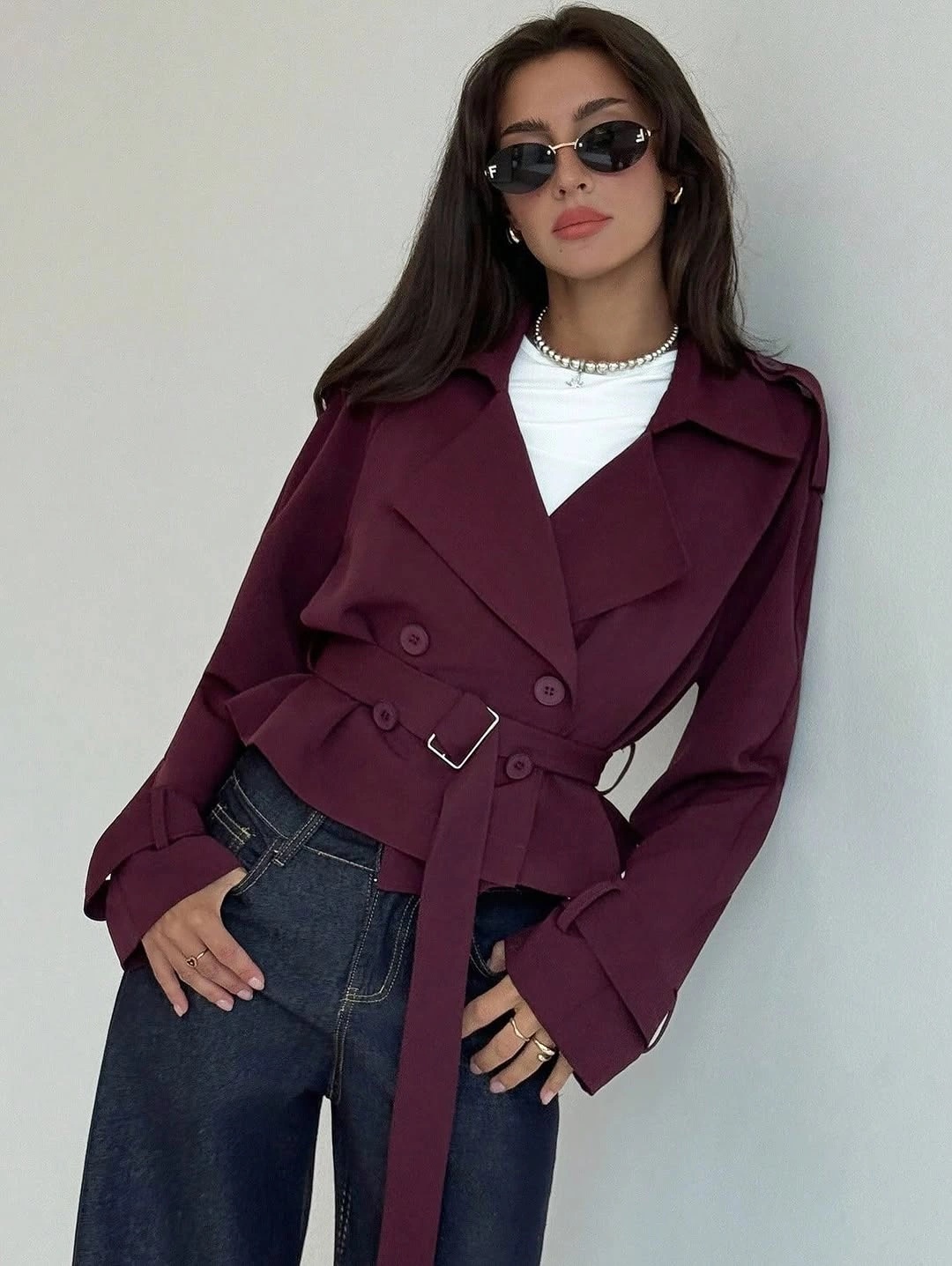Burgundy belted short trench jacket with white top and blue jeans