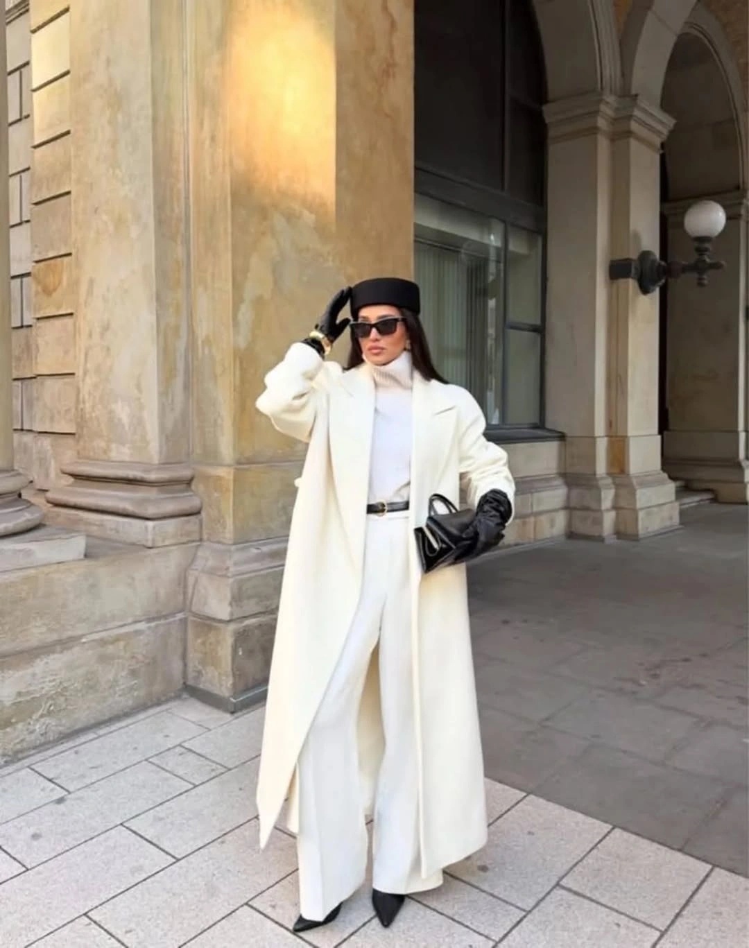 Long white coat with black belt gloves handbag and boots