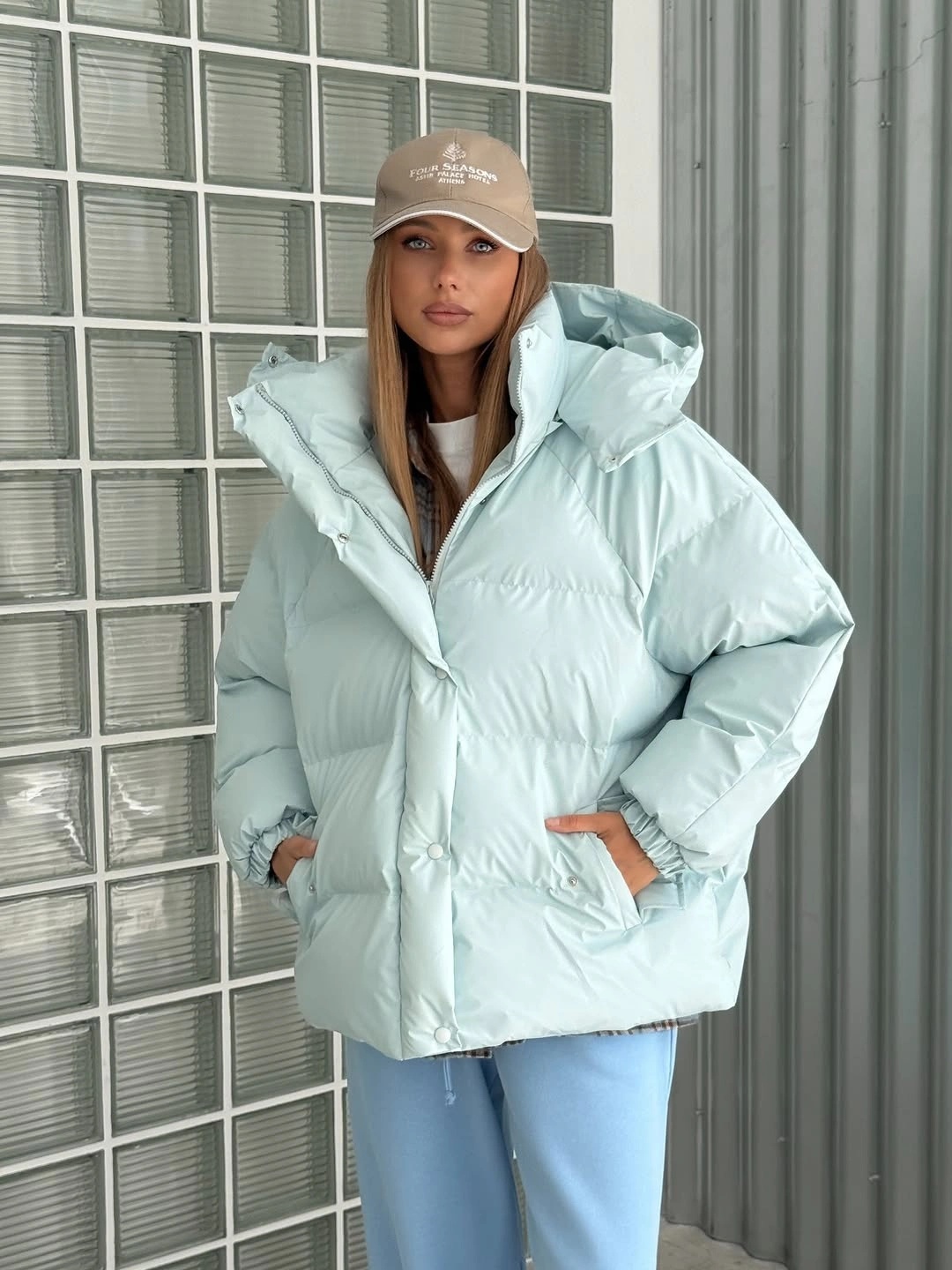 Pale blue oversized puffer with beige cap and light blue jeans