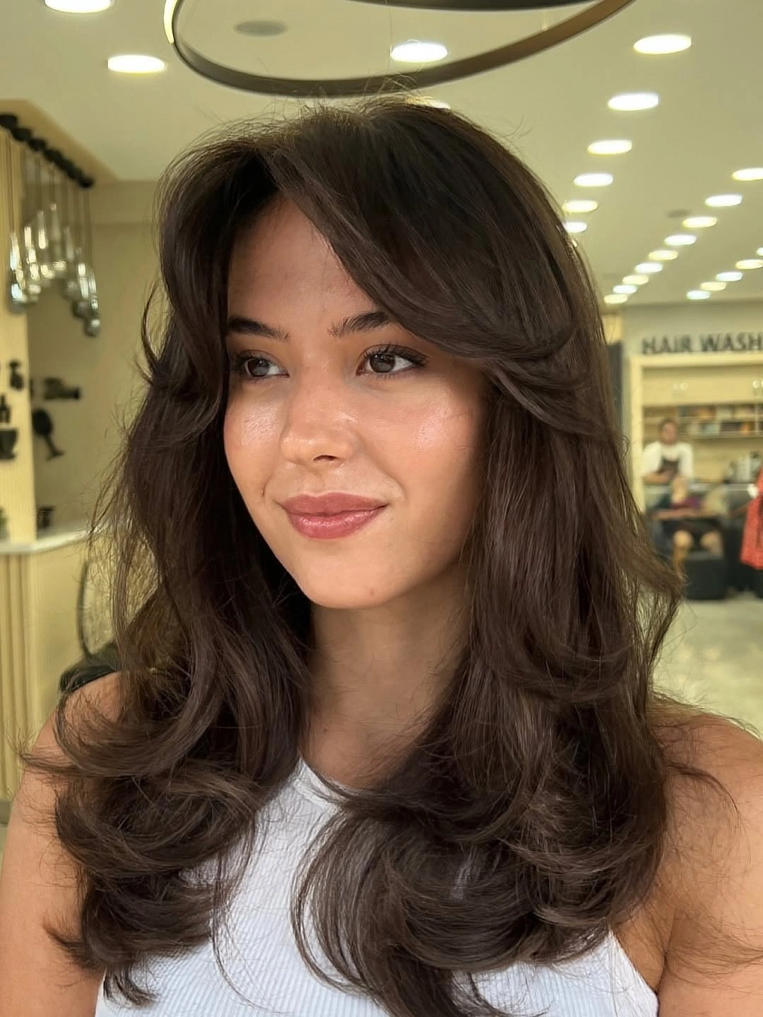 Long dark brown hair with separated lower layers and curved ends