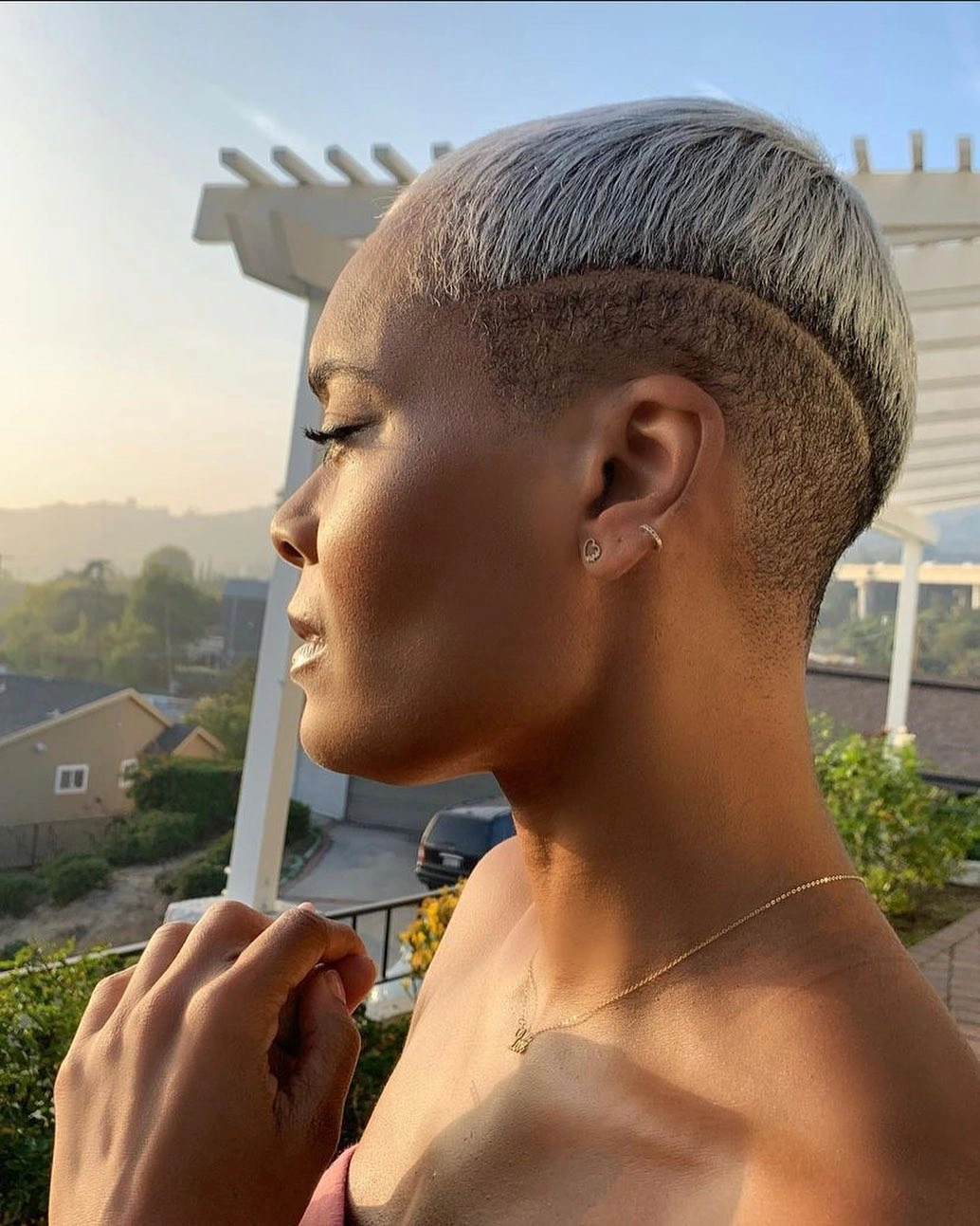 Short silver top with dark shaved sides and curved fringe
