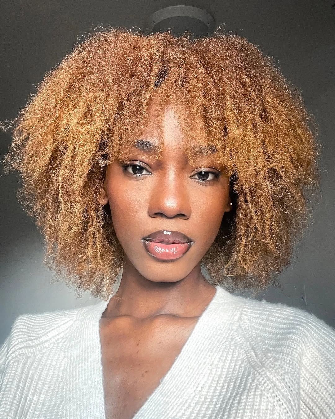 Warm golden-ginger rounded curls with visible fringe
