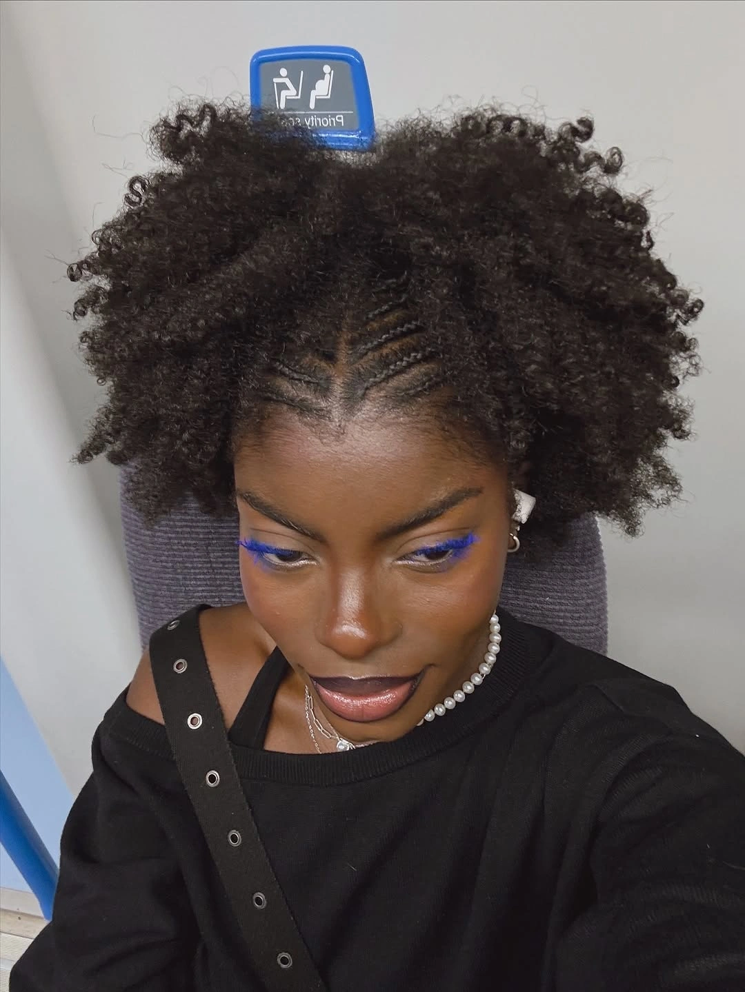 Full dark curls with a central braided part pattern