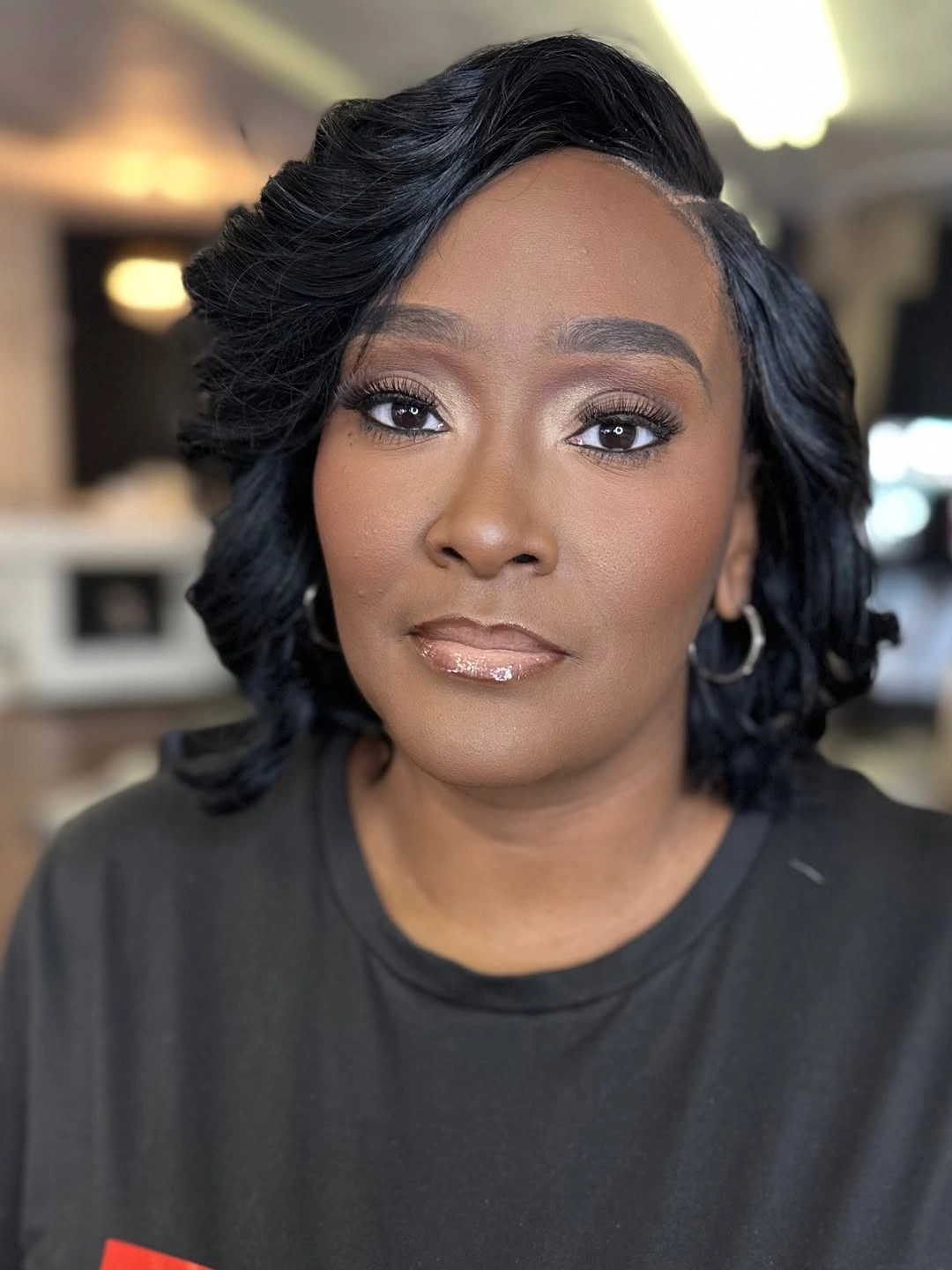 Glossy black bob with deep side part and curled ends