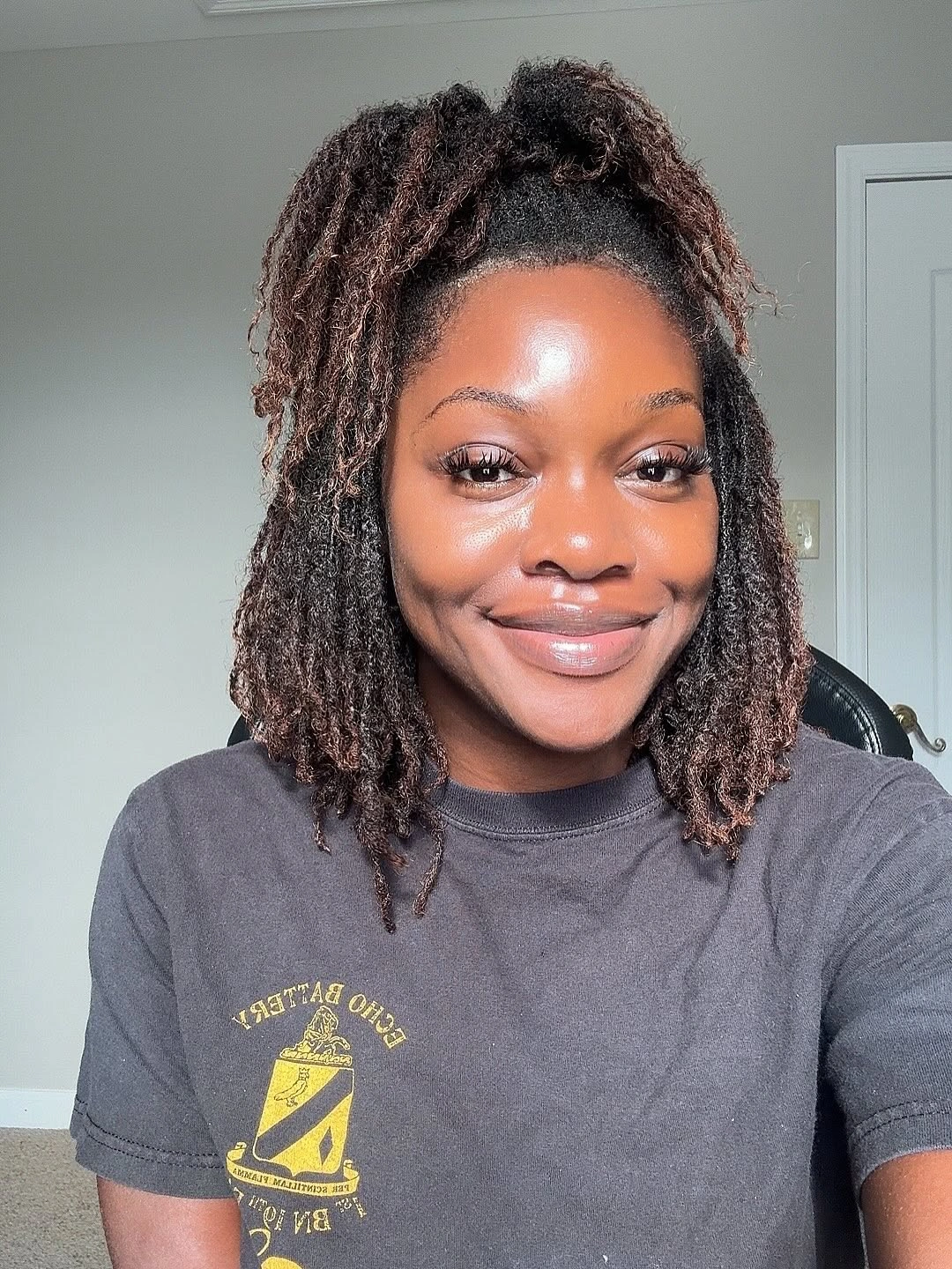 Shoulder-length loc-like strands gathered half up at crown
