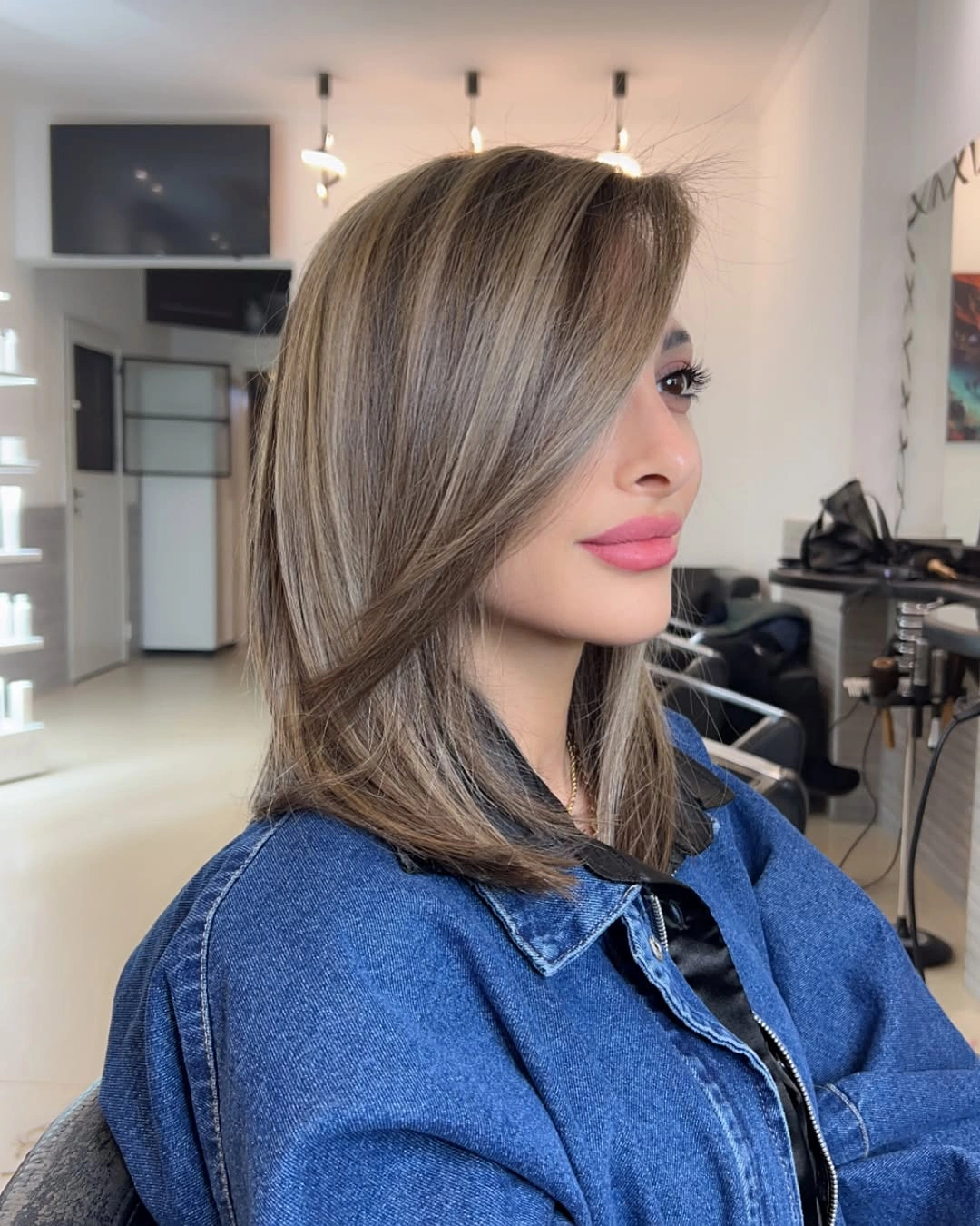 Shoulder-length ash brown hair with side part and turned ends