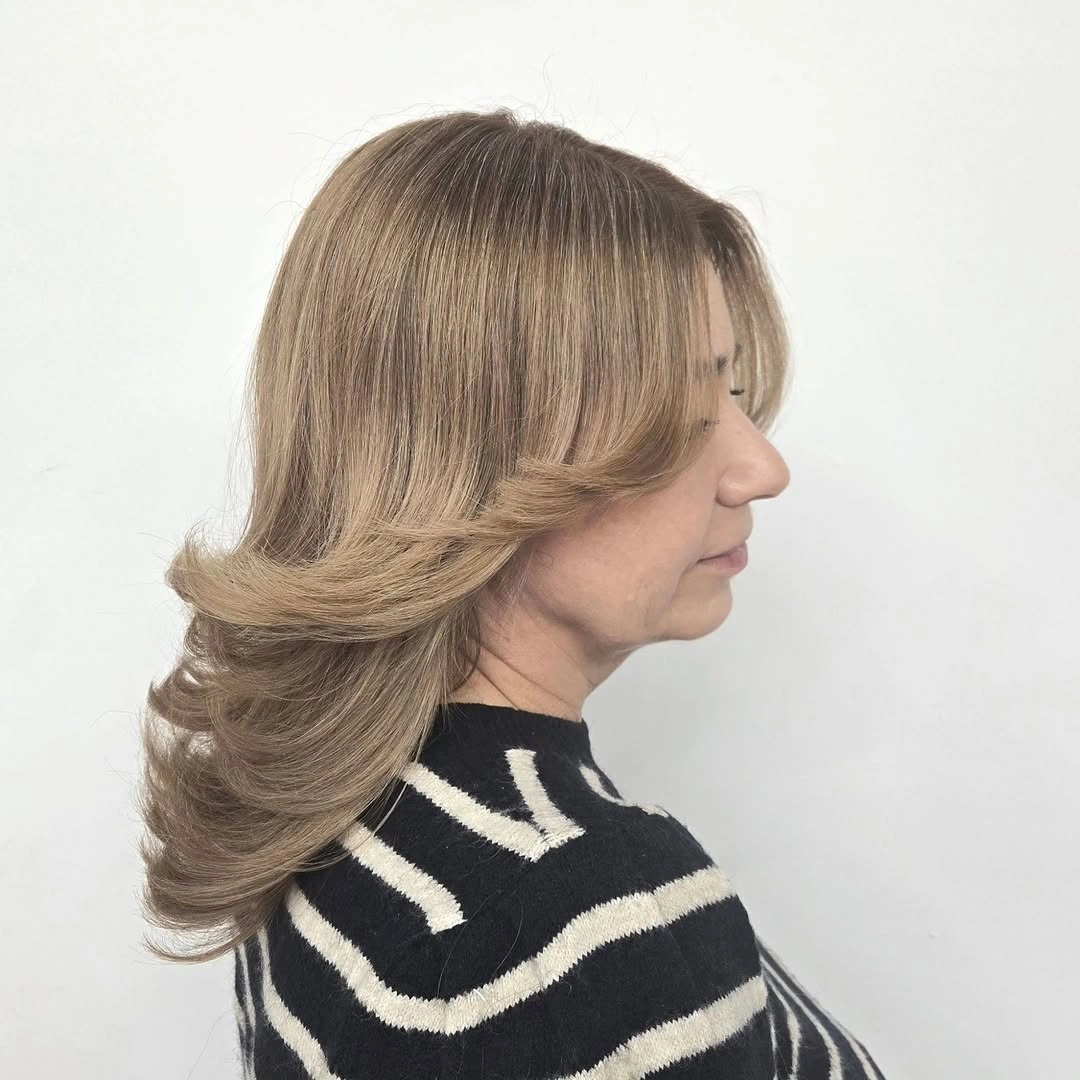 Medium light brown hair with feathered ends and outward flip