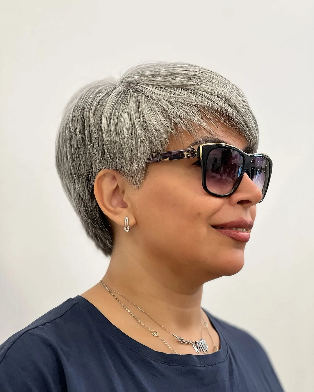 Short silver-gray cut with rounded crown and sunglasses