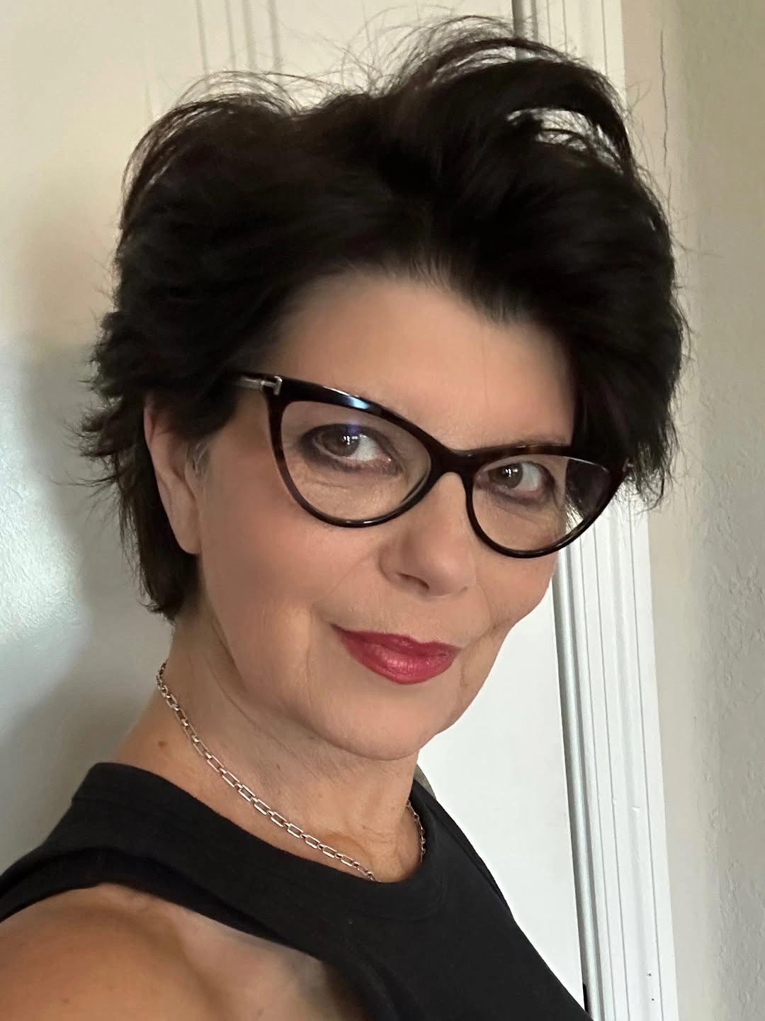Short dark swept-back hair with glasses and tapered-looking sides