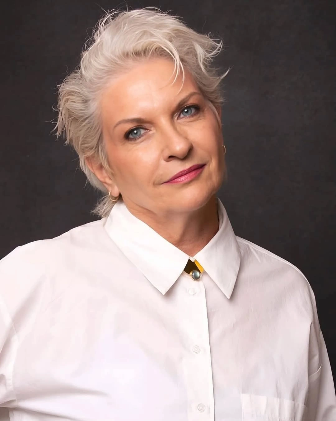 Very short white pixie-like cut with swept-up textured top