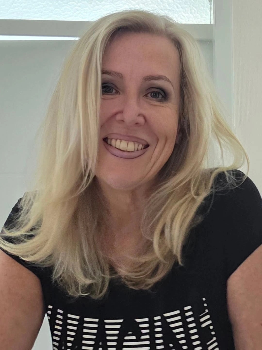 Medium-long pale blonde hair with center part and face-framing layers