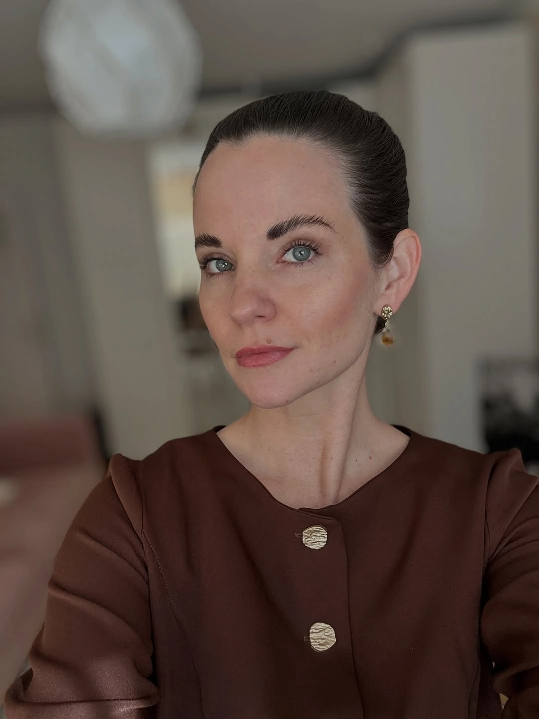 Very short dark hair brushed back away from face