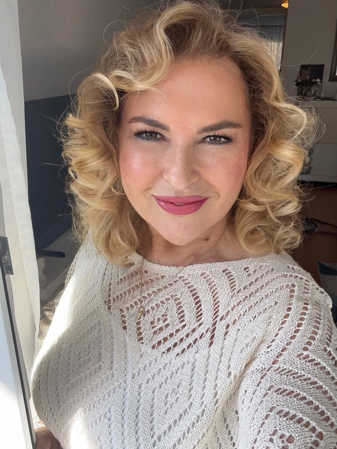 Short-to-medium blonde curls forming a face-framing bob-like shape